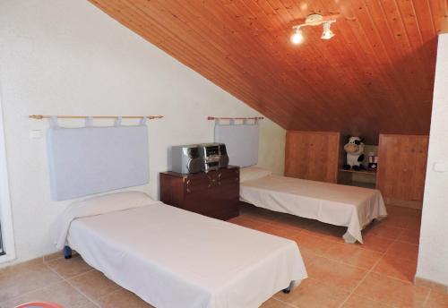 a room with two beds and a wooden ceiling at Doree 365 in L'Ametlla de Mar