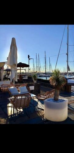 een patio met stoelen, een tafel en een plant bij maison résidence privé in Cap d'Agde