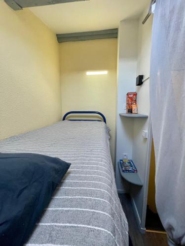 een kleine slaapkamer met een bed en een nachtkastje bij maison résidence privé in Cap d'Agde
