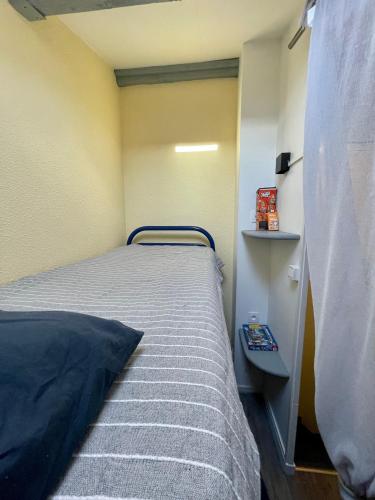une petite chambre avec un lit et une table de chevet dans l'établissement maison résidence privé, au Cap d'Agde