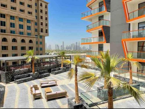 an outdoor patio with palm trees and a building at Downtown Dubai 7 minutes away from Burj Khalifa in Dubai