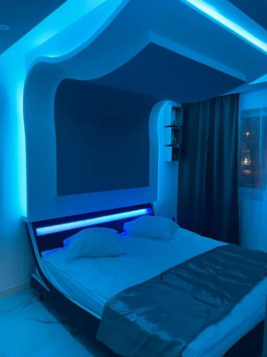 - une chambre dotée d'un lit avec des lumières bleues dans l'établissement Cozy Rental SPA, à Schiltigheim