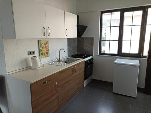 uma cozinha com armários brancos, um lavatório e um fogão em Oxford Apart Otel em Ortaca