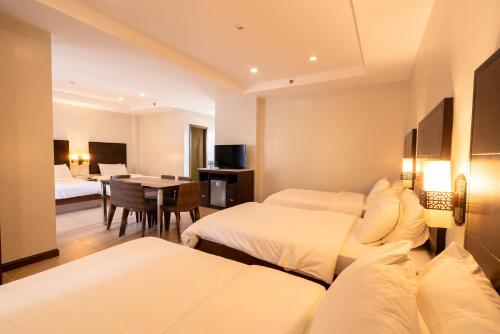 a hotel room with two beds and a dining room at MO2 Lagoon Coron in Coron
