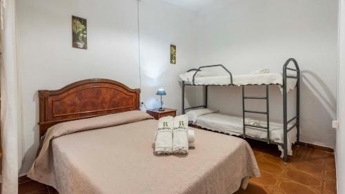 a bedroom with two beds and two bunk beds at Parajes del Chanza Cortegana by Ruralidays in Cortegana