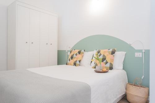 a white bedroom with a white bed with pillows at A Step from the Dome Apartment by Rent All Como in Como