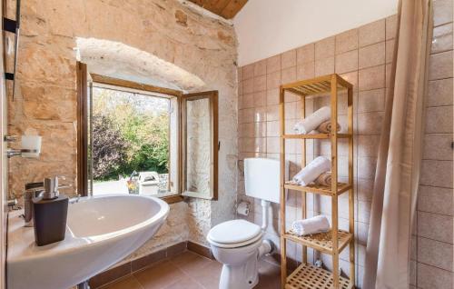 uma casa de banho com uma banheira, um lavatório e um WC. em Nice Home In Zminj With Wifi em Žminj