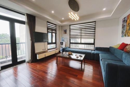 a living room with a blue couch and a table at Hanoi Home 8 - Luxury Apartment, open view in Hanoi