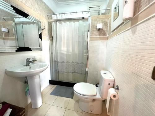 a bathroom with a toilet and a sink and a shower at Ground floor apartment very close to the sea! in Alcalá