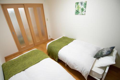 1 Schlafzimmer mit 2 Betten und einer Schiebetür in der Unterkunft MELL-THEATHER - Vacation STAY 10360 in Osaka