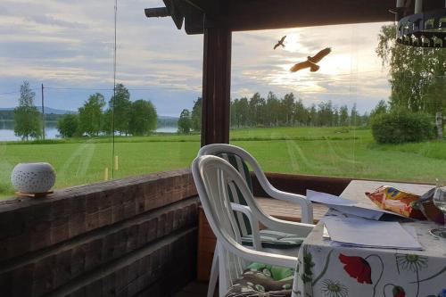 a porch with two chairs and a table and a window at Lake Lodge Rönnäs in Leksand
