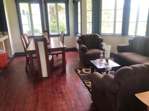 ein Wohnzimmer mit Sofas, einem Tisch und Stühlen in der Unterkunft Muchilena fishing club & suites 