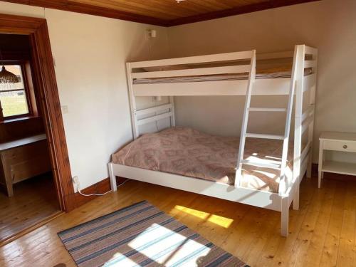 a bedroom with two bunk beds and a wooden floor at Lake Lodge Rönnäs in Leksand