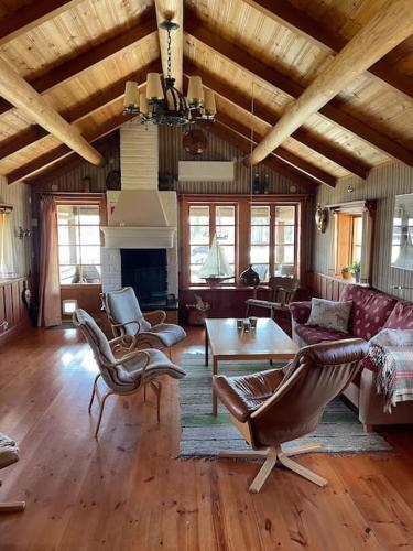 a living room with a couch and chairs and a table at Lake Lodge Rönnäs in Leksand