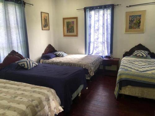 1 Schlafzimmer mit 3 Betten mit blauer und weißer Bettwäsche in der Unterkunft Muchilena fishing club & suites 