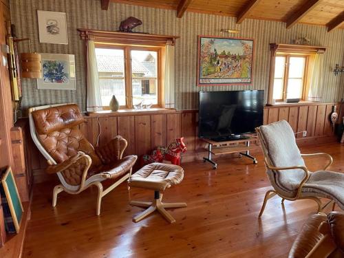 a living room with chairs and a flat screen tv at Lake Lodge Rönnäs in Leksand