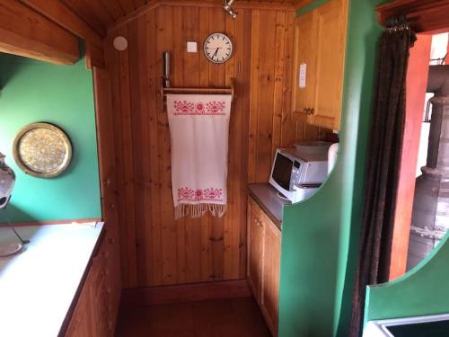 a kitchen with a clock on the wall and a towel at Lake Lodge Rönnäs in Leksand