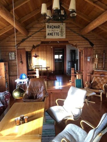 a living room with chairs and a table in a cabin at Lake Lodge Rönnäs in Leksand