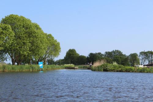 a river with a sign in the middle of it at Guesthouse at the Amstel river with 2BR 2BA and garden in Amstelveen