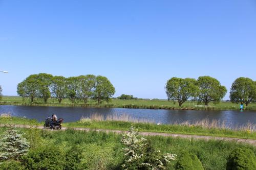 two people riding a motorcycle next to a river at Guesthouse at the Amstel river with 2BR 2BA and garden in Amstelveen