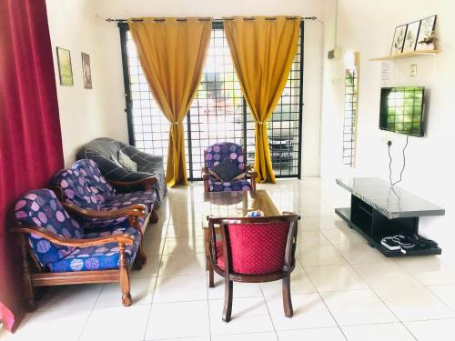 uma sala de estar com duas cadeiras e uma mesa em Homestay Lestary near Taiping Fast WIFI Netflix em Taiping