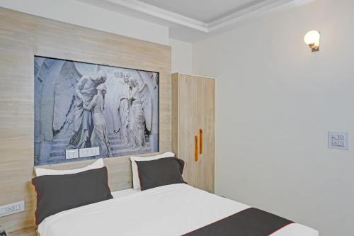 ein Schlafzimmer mit einem weißen Bett und einem Gemälde an der Wand in der Unterkunft Super Collection O Hotel Sundew in Jaipur