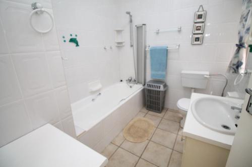 a bathroom with a tub and a toilet and a sink at Nellelani No 6 in Margate