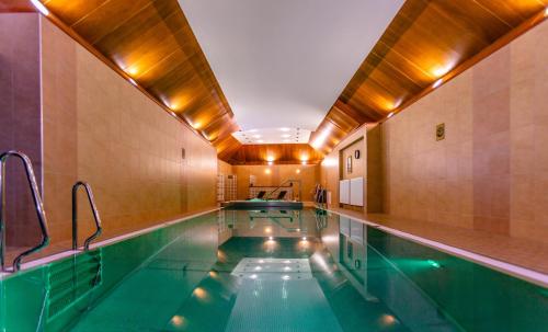 a swimming pool in a building with an indoor pool at Hotel Grand Vígľaš in Zvolen
