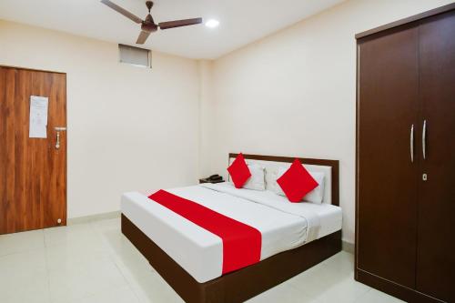a bedroom with a bed with red pillows at Hotel O Premium Hari in Jamshedpur