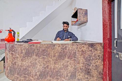 ビラースプルにあるHotel O Sai Anantの部屋のカウンターに座る男