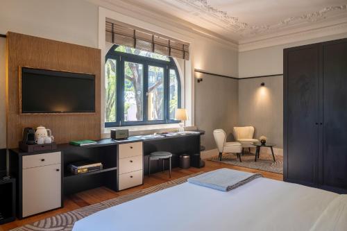 Schlafzimmer mit einem Bett, einem Schreibtisch und einem Fenster in der Unterkunft Casa da Marechal - Boutique Hotel by Oporto Collection - Adults Only in Porto