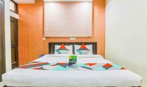 - une chambre avec un grand lit et un mur orange dans l'établissement FabExpress Mayank Palace, à Chandigarh