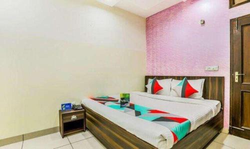 a bedroom with a bed and a purple wall at FabExpress Mayank Palace in Chandīgarh