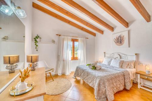 a white bedroom with a bed and a table at Ideal Property Mallorca - Can Carabassot in Pollença