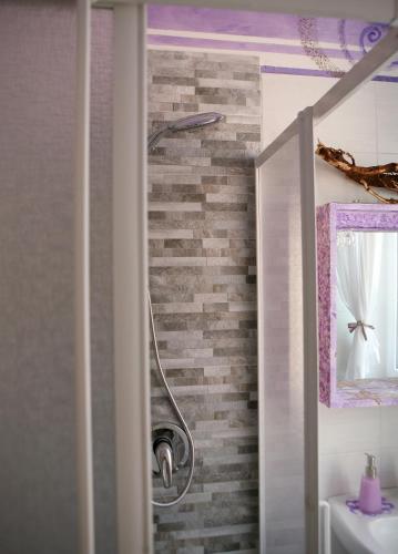 a shower in a bathroom with a brick wall at Affittacamere La Risacca in La Spezia