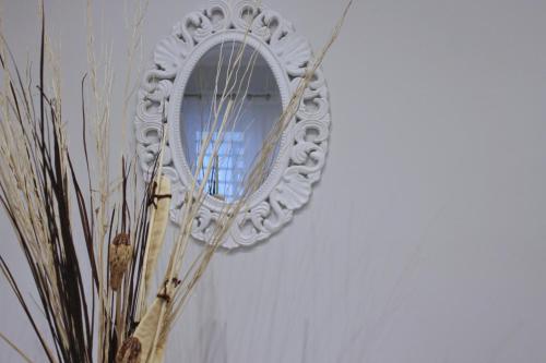 a mirror on a wall with a vase with plants at Cuore D'aMare B&B in Bari