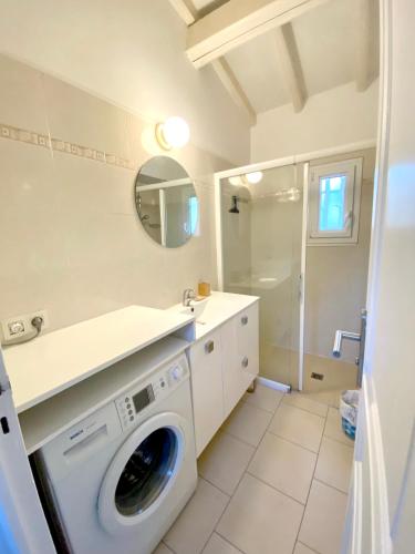- un lave-linge dans la salle de bains pourvue d'un miroir dans l'établissement Maison charmante à Sainte-Maxime avec piscine partagée, à Sainte-Maxime