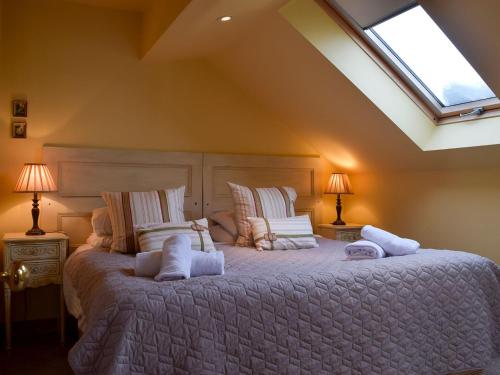 een slaapkamer met een groot bed en een dakraam bij Fennel Folly - Uk32608 in Manton