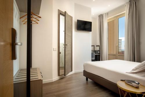 a hotel room with a bed and a mirror at Hotel La Scaletta in Lido di Ostia