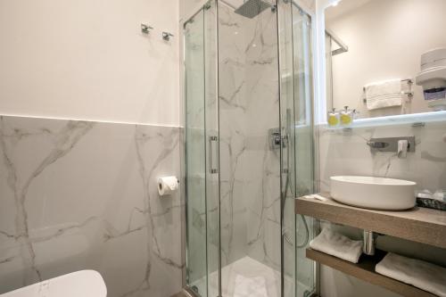 a bathroom with a glass shower and a sink at Hotel La Scaletta in Lido di Ostia