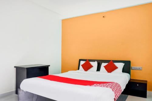 a bedroom with a large bed with red pillows at OYO Hotel Rajyog in Wagholi