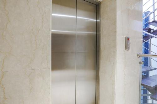 a shower stall with a metal door in a bathroom at FabHotel Grand Stay in New Delhi
