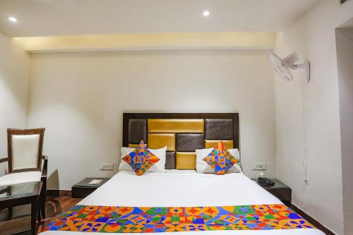 a bedroom with a large bed with a colorful comforter at FabHotel Grand Stay in New Delhi