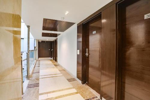a hallway with wooden doors and a hallway with tile floors at FabHotel Grand Stay in New Delhi