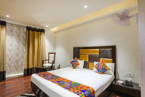 a bedroom with a large bed and a window at FabHotel Grand Stay in New Delhi