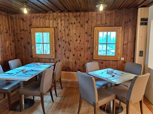 a dining room with wooden walls and tables and chairs at Ferienhof Holzmeister in Sankt Jakob in Haus