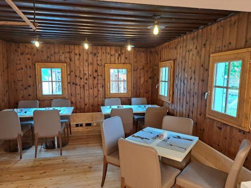 a dining room with tables and chairs and wooden walls at Ferienhof Holzmeister in Sankt Jakob in Haus