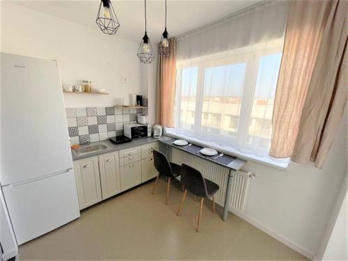 une cuisine avec une table et deux chaises ainsi qu'une fenêtre dans l'établissement apartament Onestilor, à Oradea