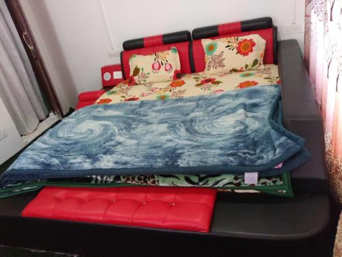 una cama en una habitación con un banco rojo al lado en OYO Home Homestay Sabzar Ahmad Gorsi, en Pahalgām