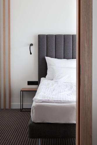 a bedroom with a large bed and a table at Hotel Shuum Boutique - Destigo Hotels in Kołobrzeg
